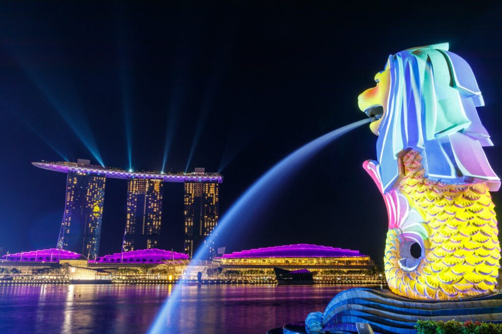Lights singing at the iconic Merlion and Marina Bay Sands in Singapore.