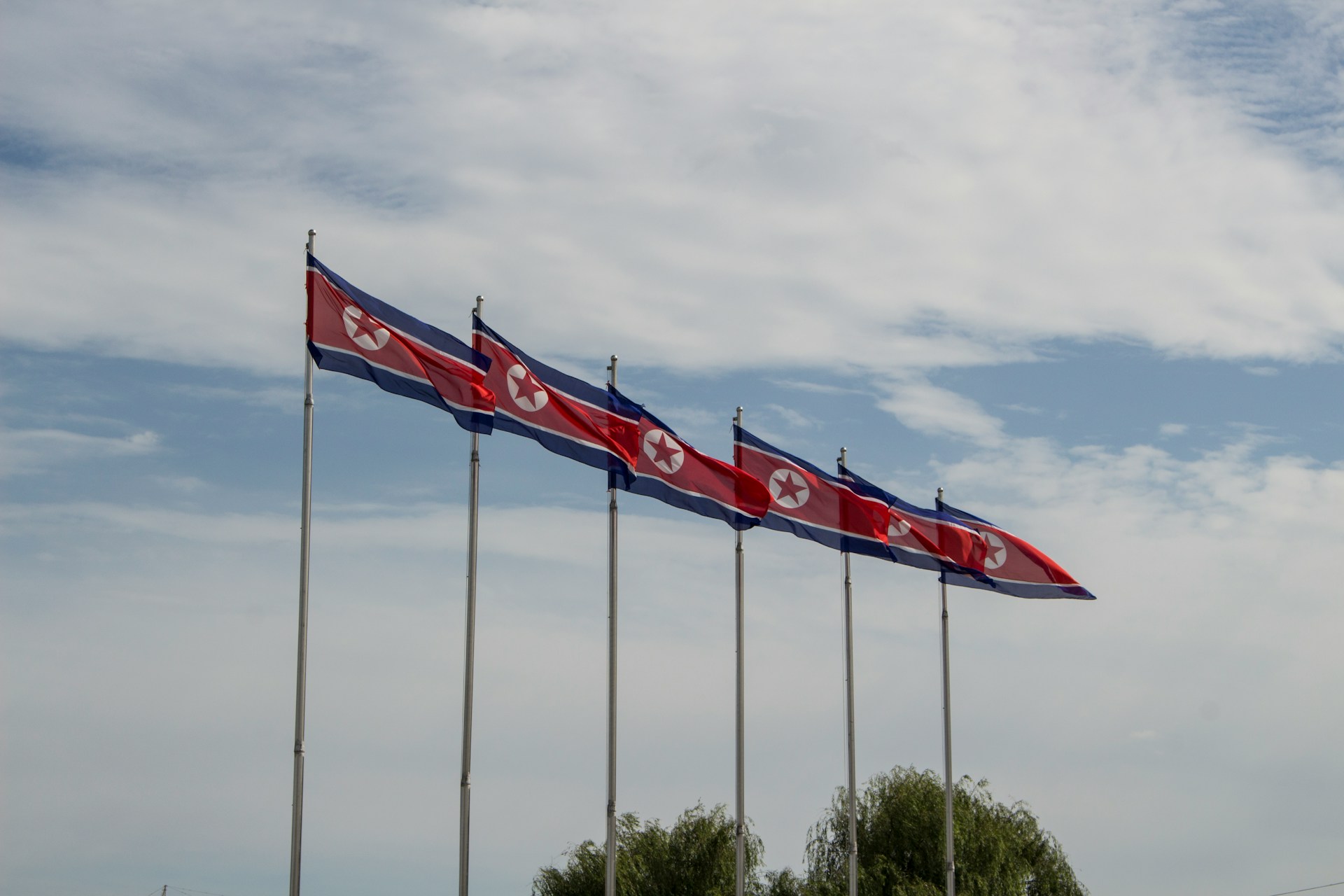 Flags if North Korea fluttering in the wind.